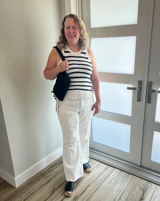 Striped knit vest and white wide-leg pants stylish outfit for women over 50