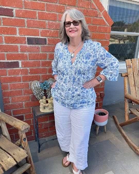 Blue floral tunic and white pants trendy outfit for women over 50