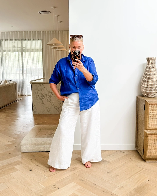Cobalt shirt and white wide-leg pants trendy outfit for women over 50