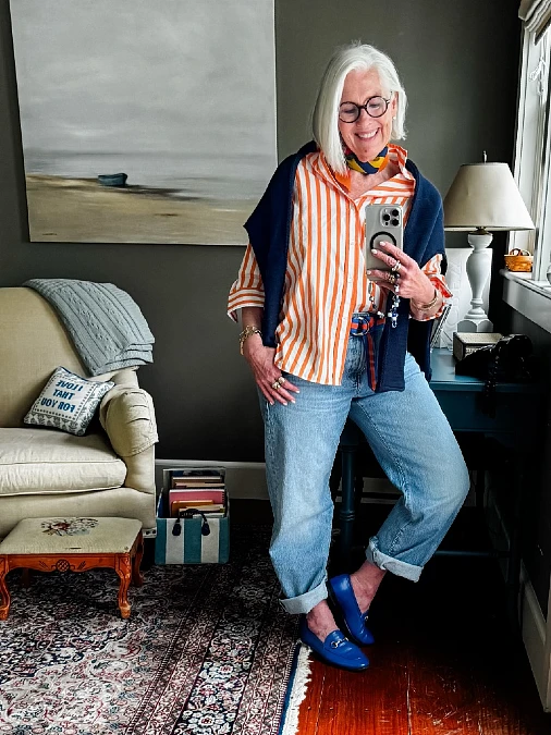 Orange striped shirt with relaxed denim and blue loafers outfit for women over 50