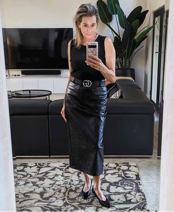 Black leather midi skirt with sleeveless knit and pointed flats outfit for women over 50