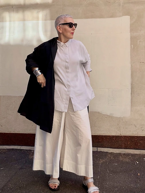 White shirt wide-leg trousers and black coat winter work outfit for women over 50