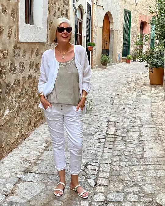 Soft white layers and satin holiday outfit for women over 50
