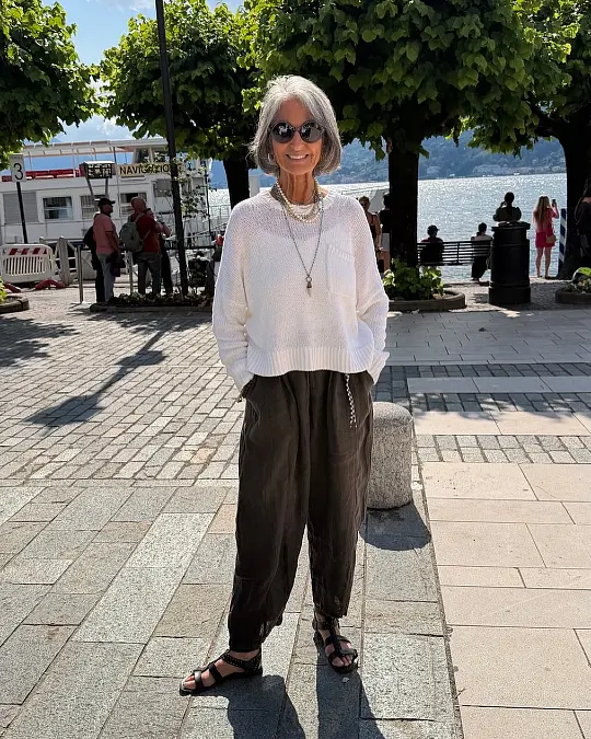 White knit and relaxed black trousers holiday outfit for women over 50